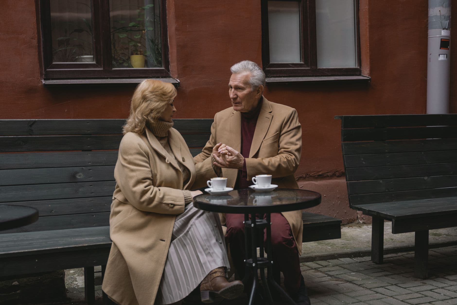 Older couple talking over coffee outdoors