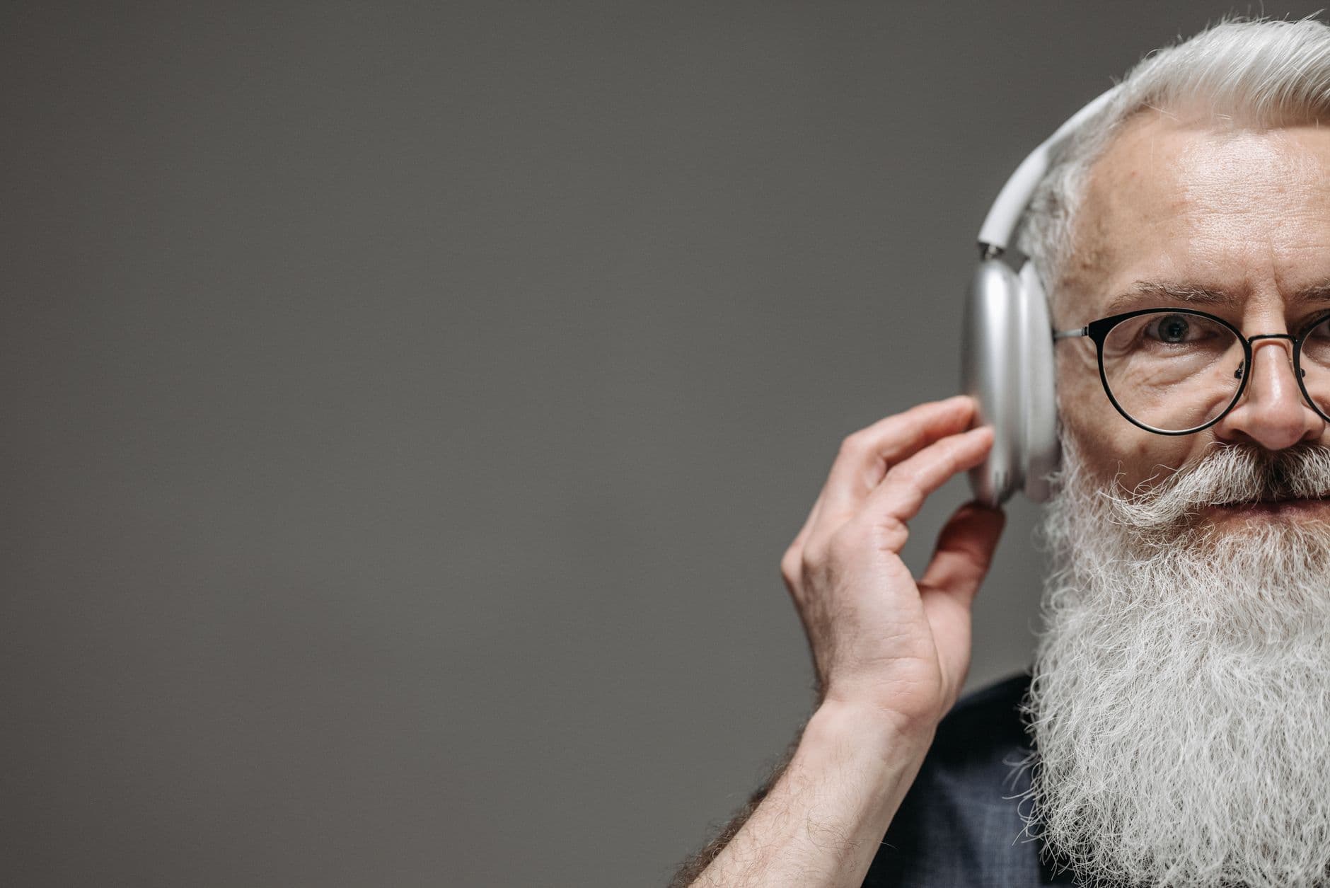 Older man wearing over-ear headphones, the same setup used for an online hearing check