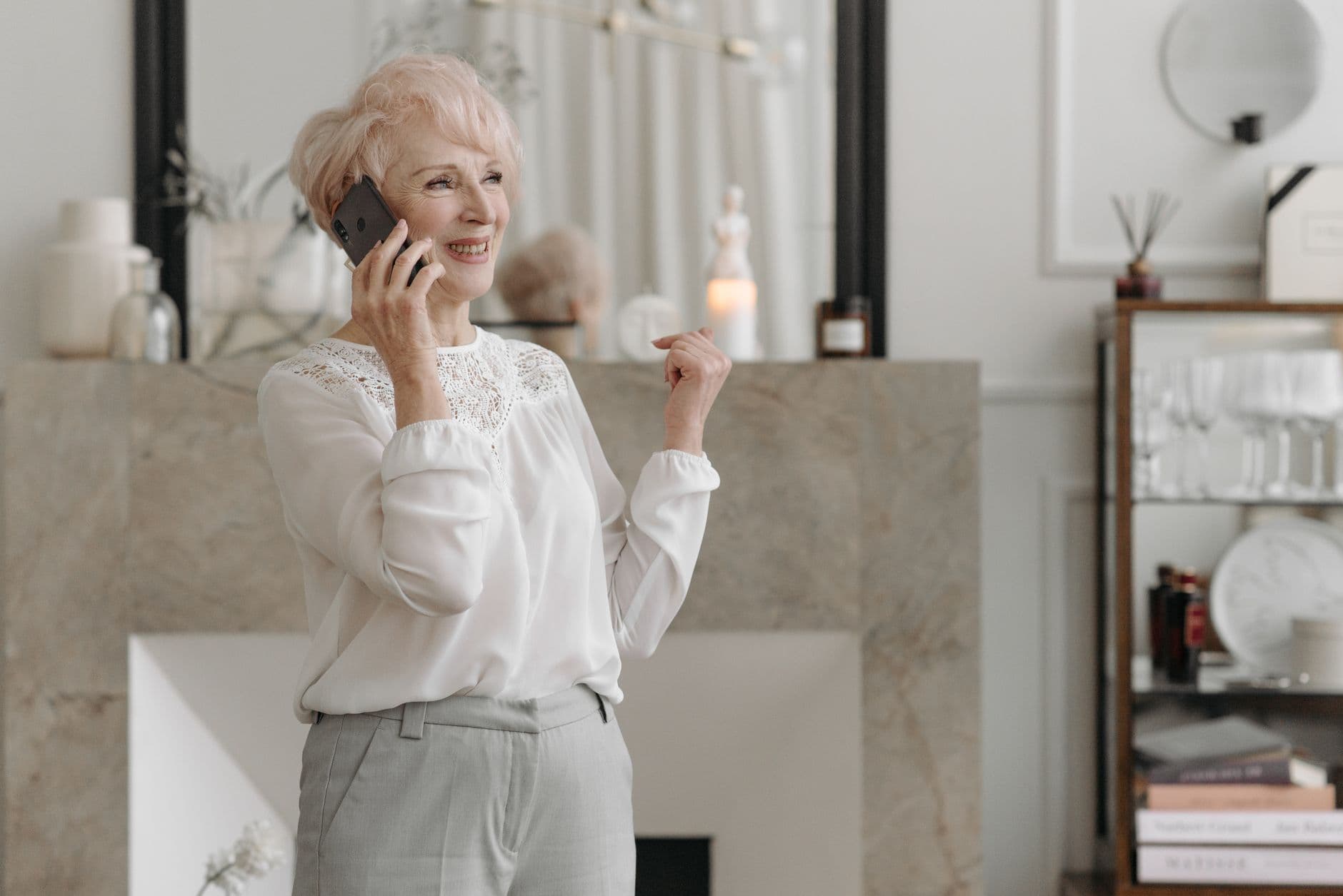 Older woman smiling while talking on a mobile phone at home