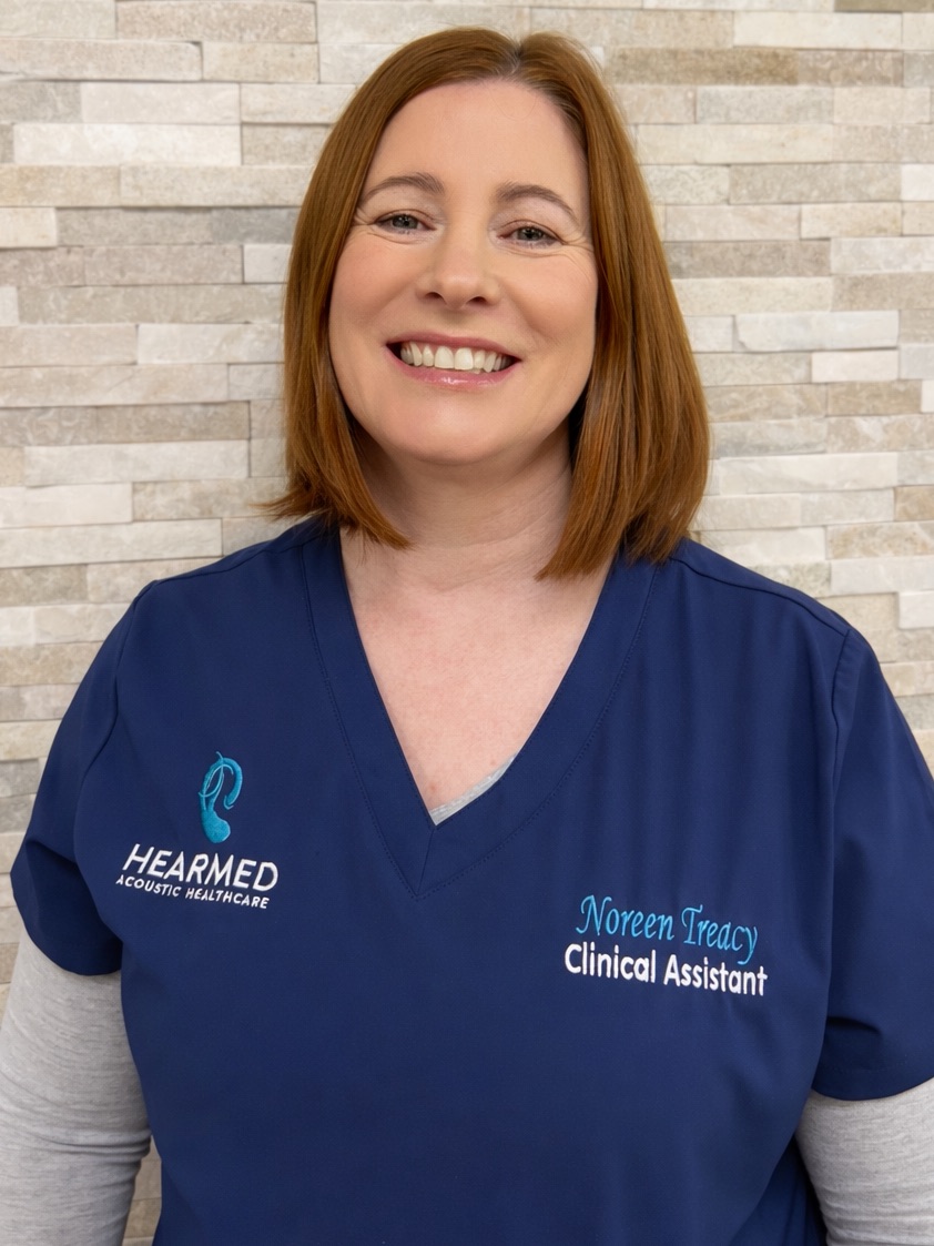 Noreen Treacy Noreen Treacy, HearMed Clinical Assistant, smiling in her blue scrubs. Acoustic Healthcare professional.