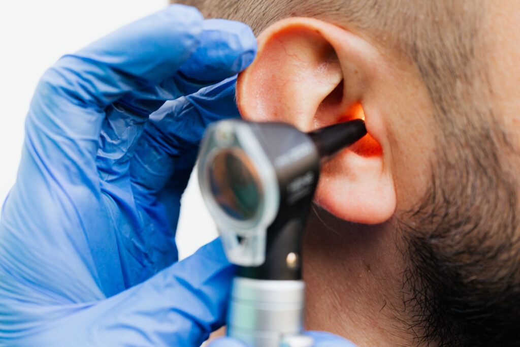 Audiologist performing a hearing test in Tullamore — otoscope examination of a patient's ear in a clinical setting.