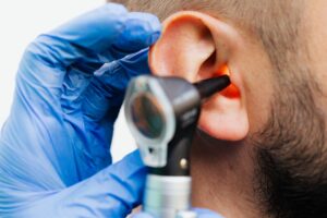 Audiologist using an otoscope to examine a patient's ear during a hearing tests in Ireland.